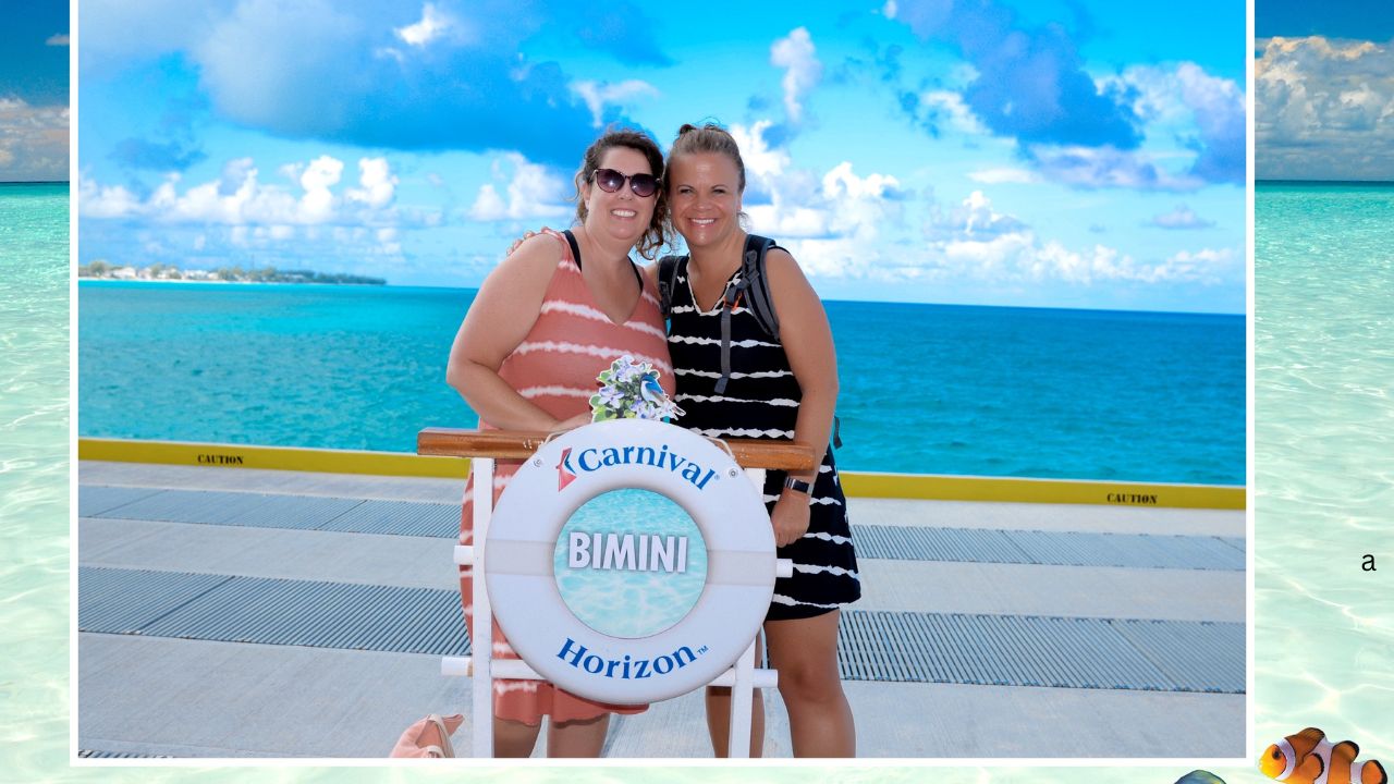 Two smiling women pose by a "Carnival Horizon Bimini" sign on a cruise ship deck, capturing the essence of their one day in Bimini with the turquoise ocean and cloudy sky as a breathtaking backdrop.