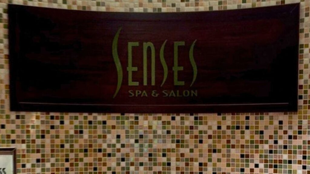 Sign reading "Senses Spa & Salon" on a mosaic tiled wall.