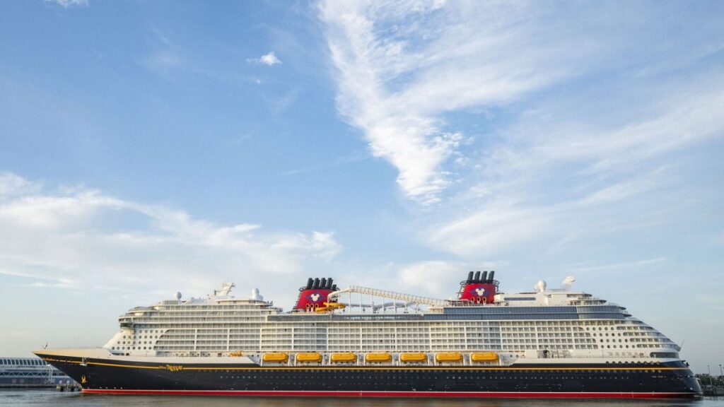 A large cruise ship docked with a clear blue sky in the background.